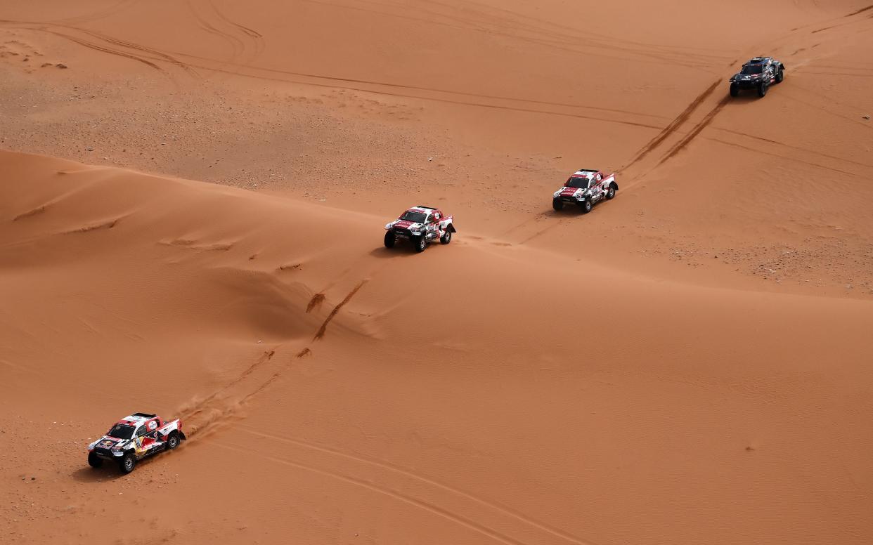 In this aerial view, Toyota's driver Nasser Al-Attiyah of Qatar (R) and his co-driver Mathieu Baumel of France ride in front Toyota's driver Giniel De Villiers of South Africa and his co-driver Dennis Murphy of South Africa, Toyota's South Arfican driver Henk Lategan and co-driver Brett Cummings of South Arfrica and Mini's driver Jakub Przygonski of Poland and his co-driver Timo Gottschalk of Germany compete during the Stage 6 of the Dakar 2021 near the Saudi capital Riyadh, on January 7, 2022. (Photo by FRANCK FIFE / AFP) (Photo by FRANCK FIFE/AFP via Getty Images)