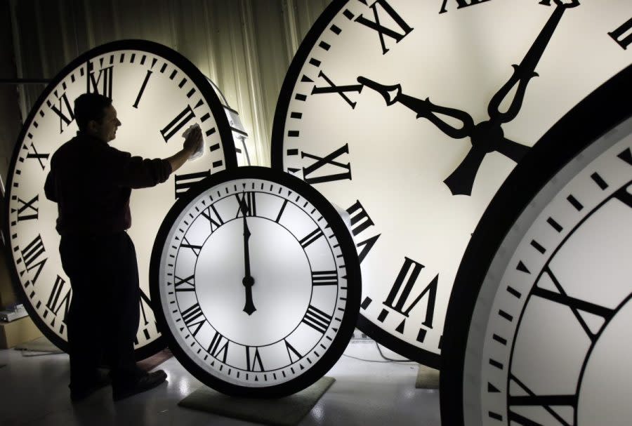 FILE - Electric Time Co. employee Walter Rodriguez cleans the face of an 84-inch Wegman clock at the plant in Medfield, Mass. Thursday, Oct. 30, 2008. Once again, most Americans will set their clocks forward by one hour this weekend, losing perhaps a bit of sleep but gaining more glorious sunlight in the evenings as the days warm into summer. There's been plenty of debate over the practice but about 70 countries — about 40 percent of those across the globe — currently use what Americans call daylight saving time. (AP Photo/Elise Amendola, File)