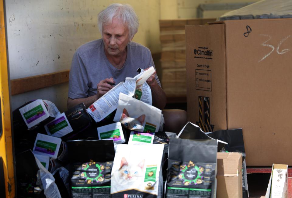 Sandy Candler sorts bags of cat food as the Pet Food Pantry of Oklahoma van makes a stop outside the former Crossbridge Community Church building in south Oklahoma City.