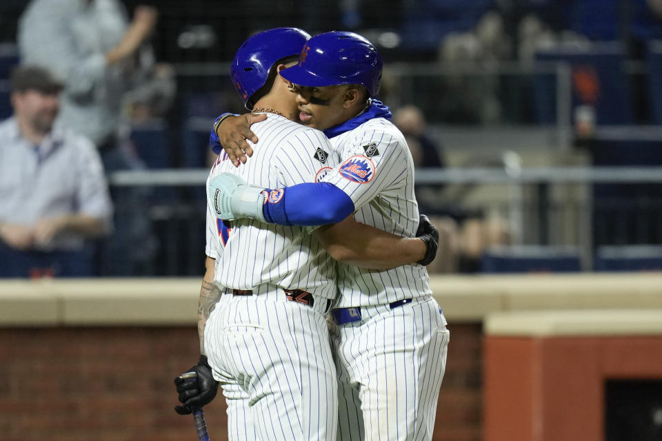 New York Mets' Francisco Lindor, right, is greeted by Francisco Alvarez after Lindor scored on a double by Joey Wendle during the seventh inning of the team's baseball game against the Pittsburgh Pirates on Tuesday, April 16, 2024, in New York. (AP Photo/Seth Wenig)