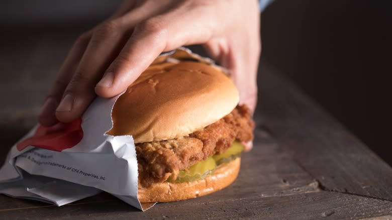 person pouring sauce into sandwich bag