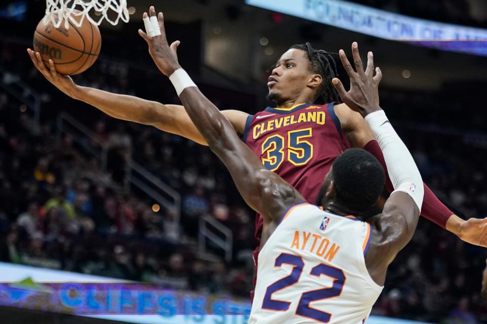 Cleveland Cavaliers' Isaac Okoro (35) drives to the basket against Phoenix Suns' Deandre Ayton (22) during the second half of an NBA basketball game Wednesday, Nov. 24, 2021, in Cleveland. (AP Photo/Tony Dejak)