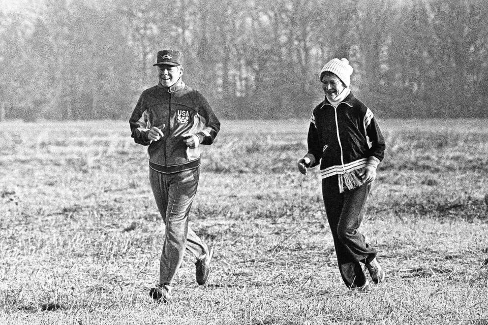 Former U.S. President Jimmy Carter and his wife Rosalynn jog across a frosty field in Plains, Ga., January 24, 1981. (AP Photo/Charles Kelly)