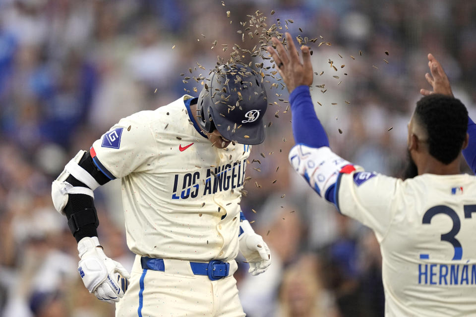 Los Angeles Dodgers' Shohei Ohtani, left, has sunflower seeds tossed at him by Teoscar Hernández after hitting a two-run home run during the third inning of a baseball game against the Los Angeles Angels Saturday, June 22, 2024, in Los Angeles. (AP Photo/Mark J. Terrill)