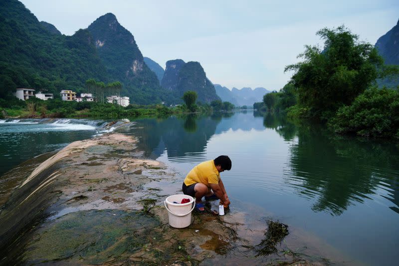 Resident washes clothes at the Yulong river in Yangshuo