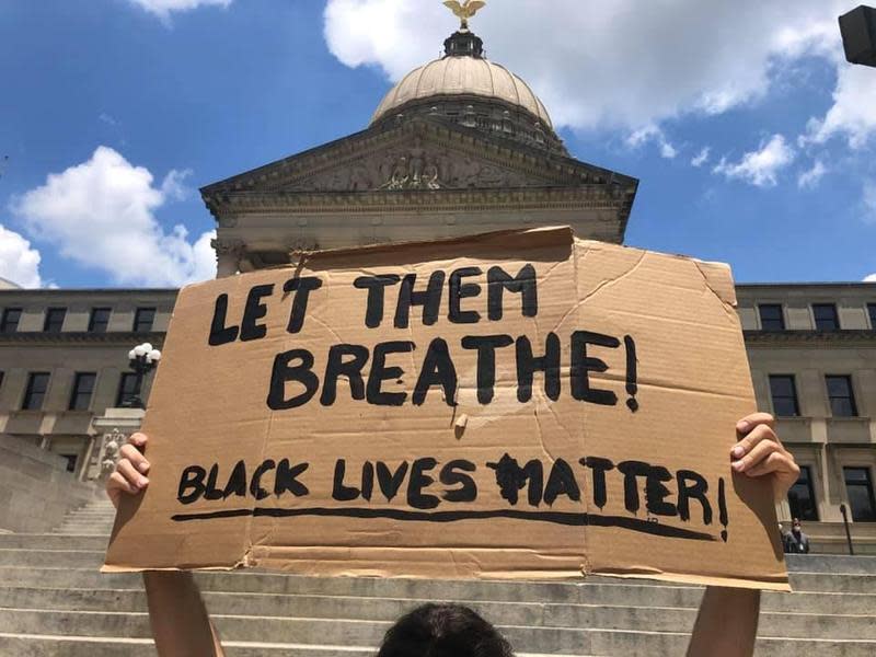 美國非裔男子佛洛伊德遭警壓頸致死，抗議民眾高舉「LET THEM BREATHE!」標語。（翻攝自16 WAPT News臉書）