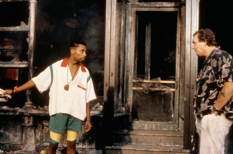 Spike Lee talks to Danny Aiello's character out the front of the burned pizza shop