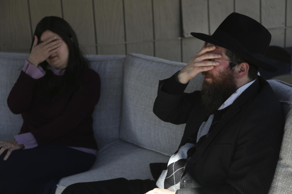 Tzivi Kivman (izq) y el rabino Yossi Kivman recitan la shema, una plegaria judía, con Michelle y Bob Pepe durante una visita a su casa de Sharon, Massachusetts, para ofrecerles consuelo tras la muerte del padre de Michelle por el COVID-19. Michelle Pepe cree que ella le pasó el virus a su padre y se siente culpable. Foto del 14 de abril del 2021. (AP Photo/Jessie Wardarski)