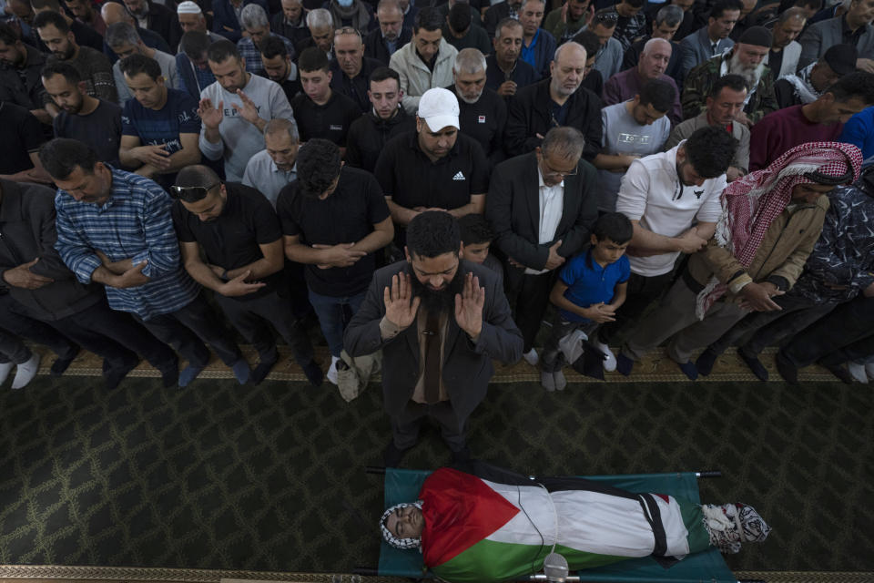 Palestinian mourners pray over the body of Muhammad Assaf during his funeral at a mosque in the West Bank village of Kufr Laqef, near Qalqiliya, Wednesday, April 13, 2022. Israeli forces shot and killed Assaf, 34, during clashes on Wednesday, the Palestinian Health Ministry said, as Israeli troops continued a days-long operation in the occupied West Bank in response to a spate of deadly attacks. (AP Photo/Nasser Nasser)