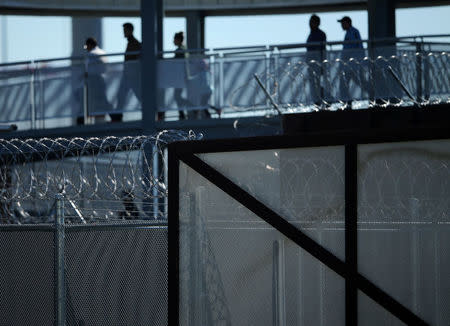 Pedestrians walk past fences and and barb wire as they make their way from Mexico to the United States at the border crossing in San Ysidro, California, U.S., January 25, 2017. REUTERS/Mike Blake