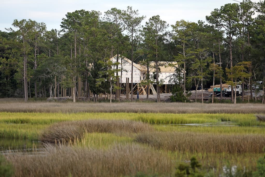 Homes are visible under construction near wetlands in Oak Island, N.C.,