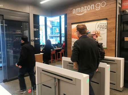 A customer walks out of the Amazon Go store, without needing to pay at a cash register due to cameras, sensors and other technology that track goods that shoppers remove from shelves and bill them automatically after they leave, in Seattle, Washington, U.S., January 18, 2018. Photo taken January 18, 2018. REUTERS/Jeffrey Dastin