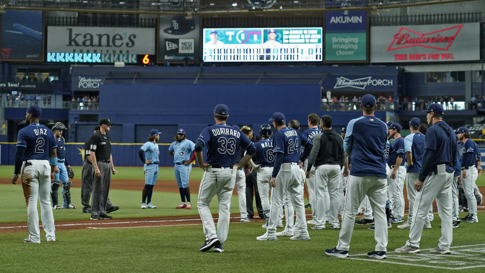Tampa Bay Rays and Toronto Blue Jays players stand on the field after Blue Jays pitcher Ryan Borucki hit Rays' Kevin Kiermaier with a pitch during the eighth inning of a baseball game Wednesday, Sept. 22, 2021, in St. Petersburg, Fla. (AP Photo/Chris O'Meara)