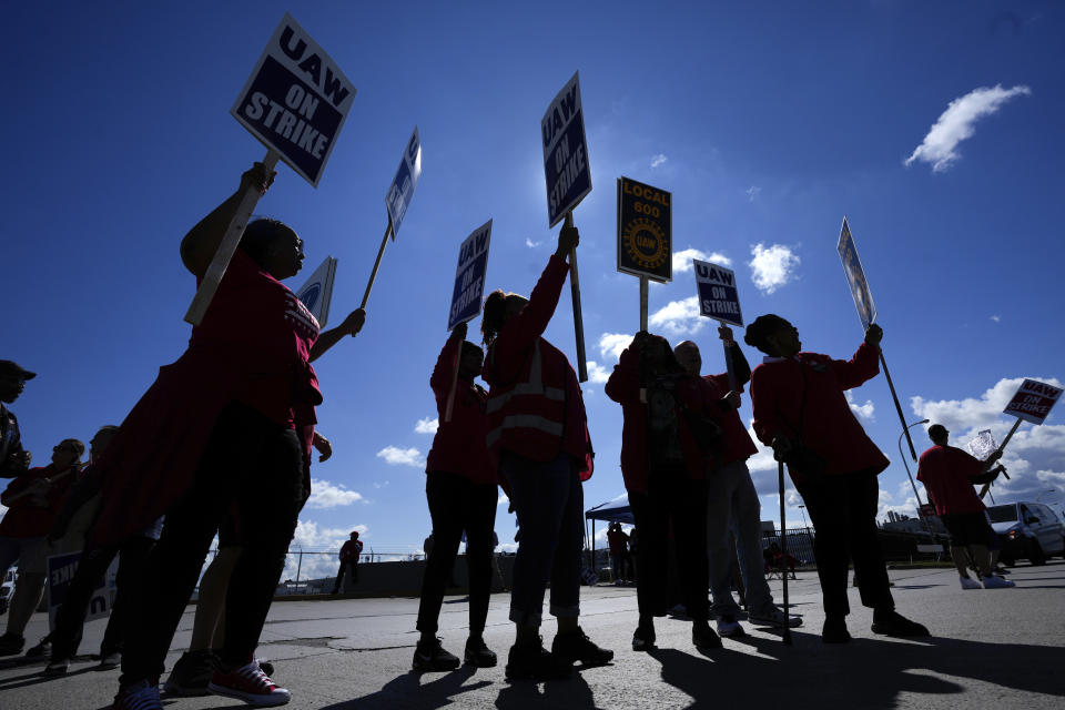 File - United Auto Workers members walk the picket line at the Ford Michigan Assembly Plant in Wayne, Mich., Sept. 18, 2023. The long-battered American labor movement flexed its muscle in 2023, taking advantage of widespread worker shortages to demand – and get -- better pay and benefits. (AP Photo/Paul Sancya, File)