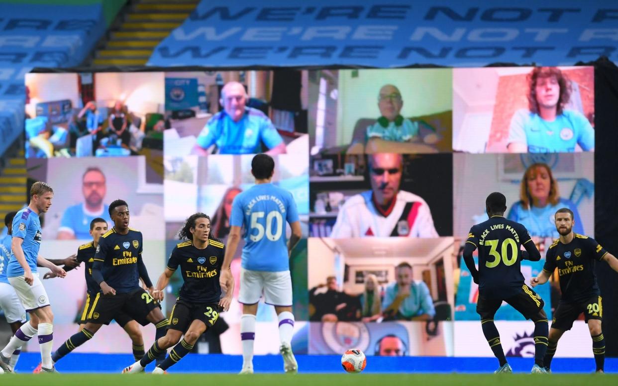 A giant screen shows fans' reactions during yesterday's match between Manchester City and Arsenal at the Etihad Stadium - AFP