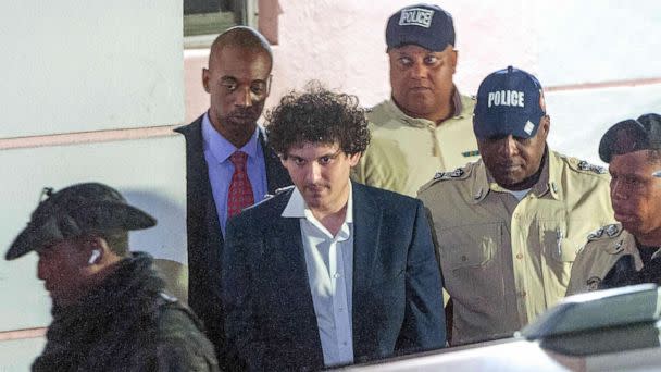 PHOTO: FTX founder Sam Bankman-Fried (C) is led away handcuffed by officers of the Royal Bahamas Police Force in Nassau, Bahamas, Dec. 13, 2022. (Mario Duncanson/AFP via Getty Images)