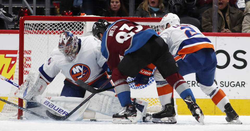 New York Islanders goaltender Semyon Varlamov, left, stops a shot by Colorado Avalanche left wing Matt Nieto as Islanderss defenseman Nick Leddy covers during the second period of an NHL hockey game Wednesday, Feb. 19, 2020, in Denver. (AP Photo/David Zalubowski)