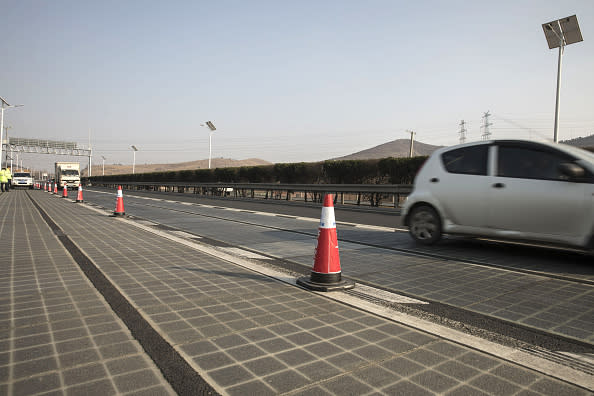 Vehicles travel on photovoltaic lanes developed by Qilu Transportation Development Group Co. on a highway in Jinan, China. About 45,000 vehicles barrel over the 3,540-foot-long section every day, and the solar panels inside generate enough electricity to power highway lights and 800 homes, according to Qilu Transportation. Photographer: Qilai Shen/Bloomberg