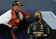 Max Verstappen (left) celebrates on the podium next to Lewis Hamilton