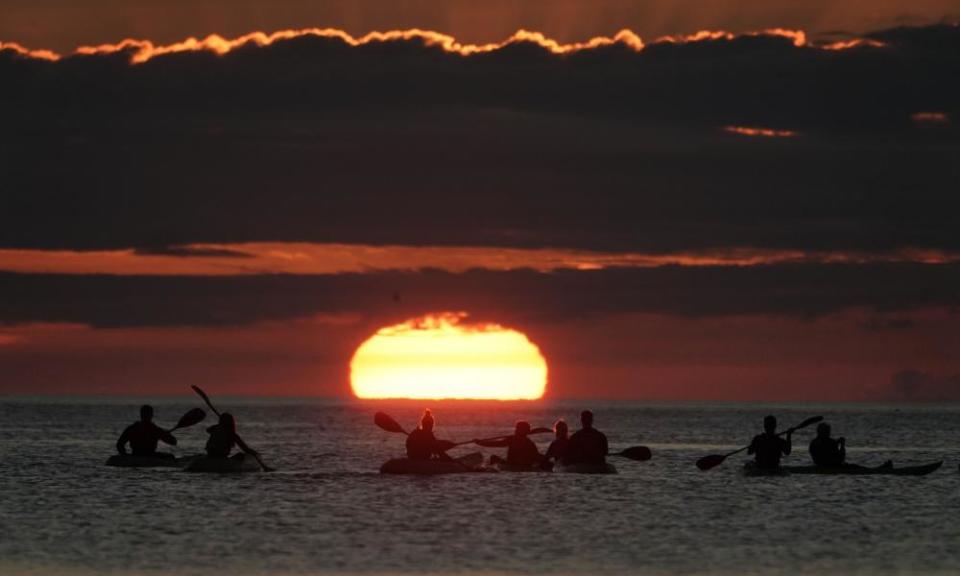 Kayakers watching the sunrise early on Saturday morning at Cullercoats bay in North Tyneside.