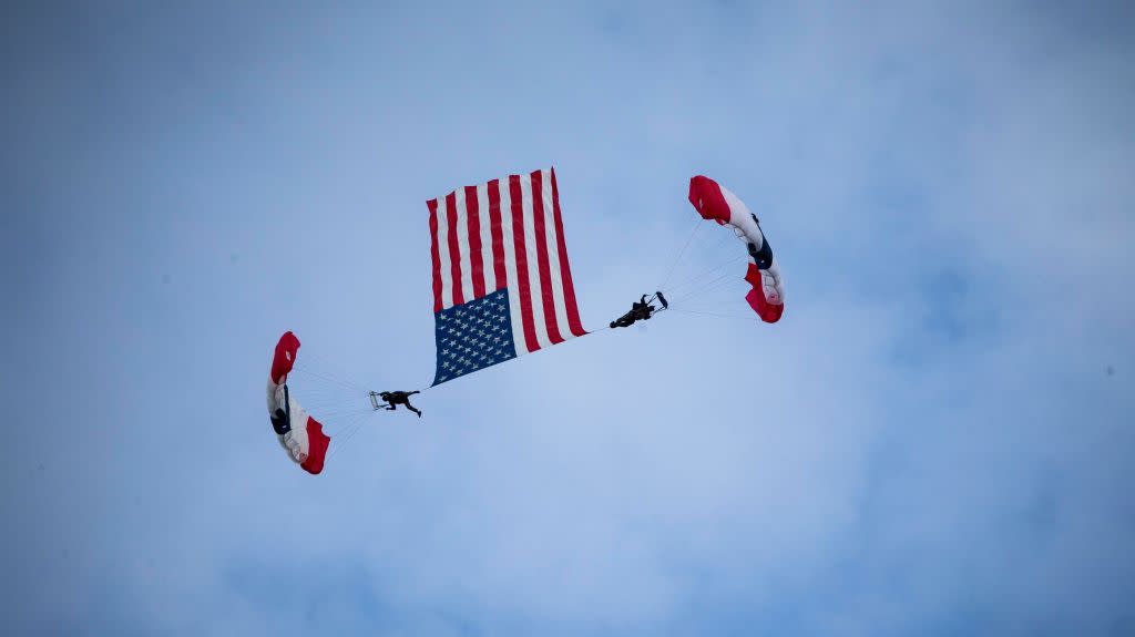 Skydivers fly an American flag