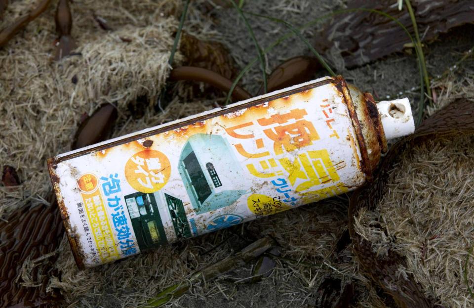 What looks like a rusty spray can, embellished with Japanese writing, is washed up on the shores of Long Beach, Canada. One to five percent of the 0.9 - 1.8 million tonnes of debris still floating in the ocean could reach Hawaii, Alaska, Oregon and Washington and British Columbia, according to University of Hawaii senior researcher and ocean current expert Nikolai Maximenko.