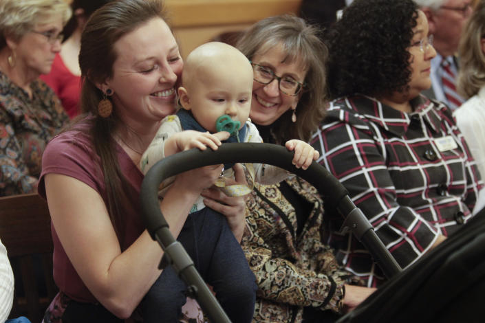 Korbe Bohac holds her nearly 8-month-old son, Winston, ahead of a hearing by the Kansas Senate tax committee on a bill that would grant a 70% income tax credit to donors to what supporters call "pregnancy resource centers" run by groups that oppose abortion and offering free services, including pregnancy tests, sonograms and parenting classes, Thursday, Feb. 2, 2023, at the Statehouse in Topeka, Kan. Bohac received services from the Insight Women's Clinic in Lawrence before and after Winston's birth and urged lawmakers to approve the bill. (AP Photo/John Hanna)
