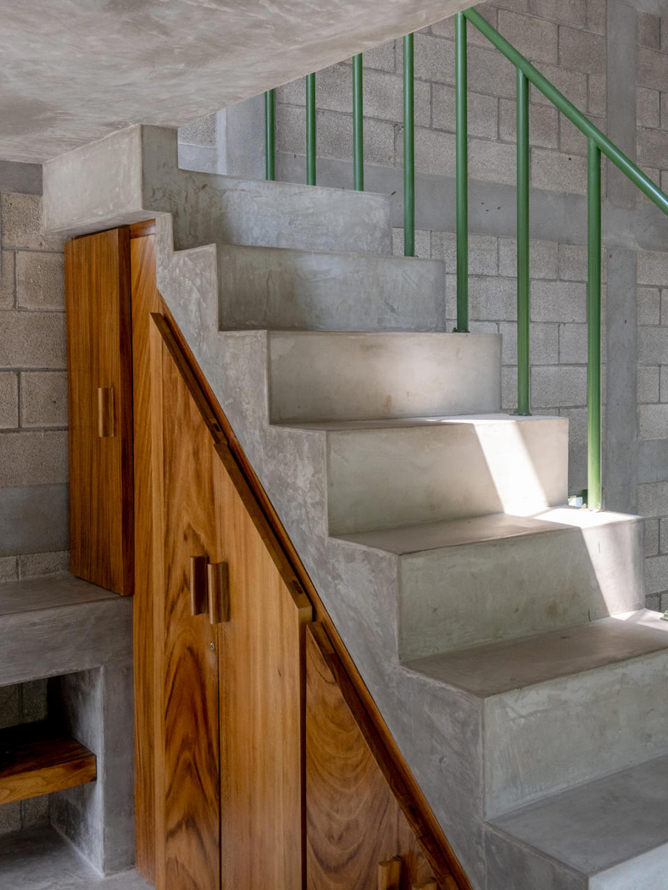 interior concrete staircase with green railing