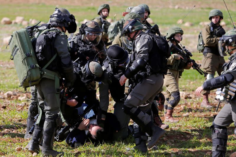Israeli forces detain a Palestinian demonstrator during a protest against the U.S. President Donald Trump's Middle East peace plan, in Jordan Valley in the Israeli-occupied West Bank