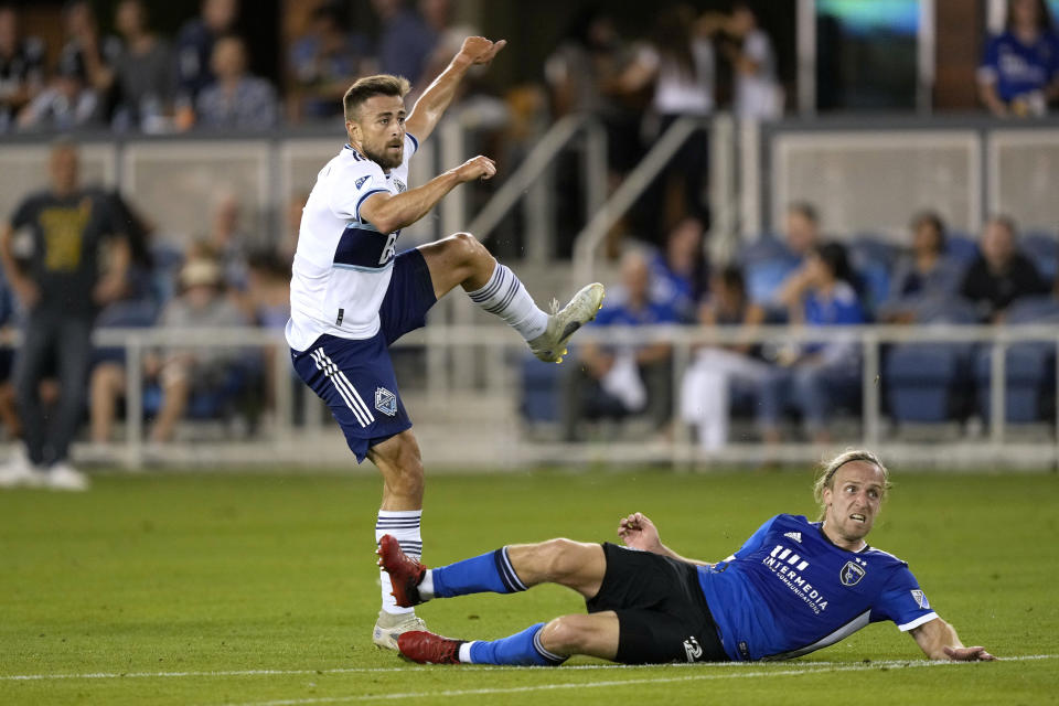 Vancouver Whitecaps defender Marcus Godinho, left, takes a shot at a goal over San Jose Earthquakes forward Tommy Thompson, bottom, during the second half of an MLS soccer match in San Jose, Calif., Sunday, Sept. 4, 2022. San Jose won 2-0. (AP Photo/Tony Avelar)