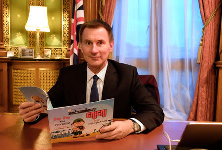 Britain's Foreign Secretary Jeremy Hunt is seen with a copy of "Jay Jay the Journalist" written by Wa Lone, one of two Reuters reporters currently imprisoned in Myanmar, whilst working in his office in London, Britain, December 20, 2018. REUTERS/Toby Melville