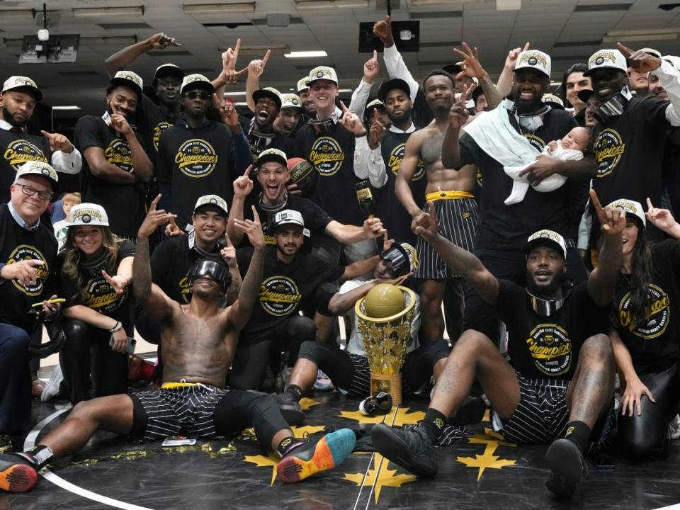 Hamilton Honey Badgers players and team members celebrate with the championship trophy after defeating Scarborough Shooting Stars 90-88 in the CEBL championship final at TD Place in Ottawa. (Adrian Wyld/The Canadian Press - image credit)