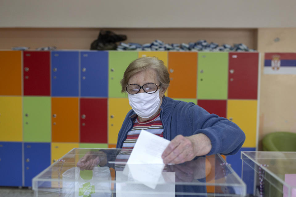 A woman casts her ballot at a polling station in Belgrade, Serbia, Sunday, June 21, 2020. Serbia's ruling populists are set to tighten their hold on power in a Sunday parliamentary election held amid concerns over the spread of the coronavirus in the Balkan country and a partial boycott by the opposition. (AP Photo/Marko Drobnjakovic)