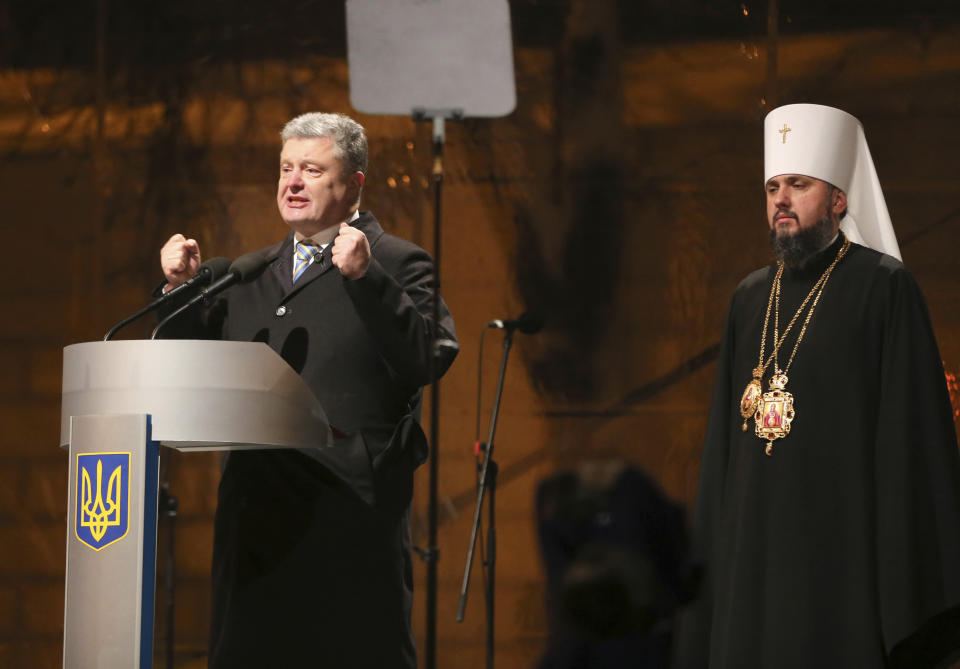Ukrainian President Petro Poroshenko, left, speaks to people as a new elected head of independent Ukrainian church Metropolitan of Kiev Epiphanius looks on near the St. Sophia Cathedral in Kiev, Ukraine, Saturday, Dec. 15, 2018. Ukraine's Orthodox clerics gather for a meeting Saturday that is expected to form a new, independent Ukrainian church, and Ukrainian authorities have ramped up pressure on priests to support the move. (AP Photo/Efrem Lukatsky)