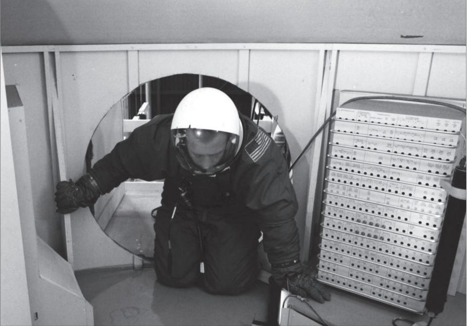 Astronaut crawling in spacesuit at MOL.