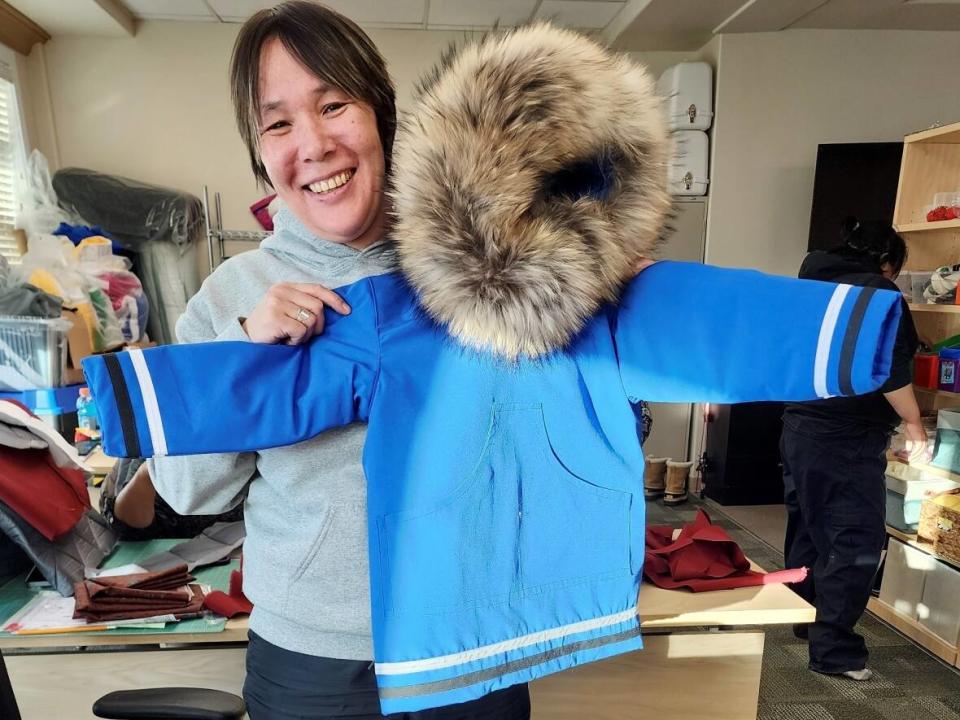 Rita Akearok holds up a parka she made as part of a three-week parka making course at Nunavut Arctic College in Iqaluit.  (Submitted by Mariana Barney - image credit)