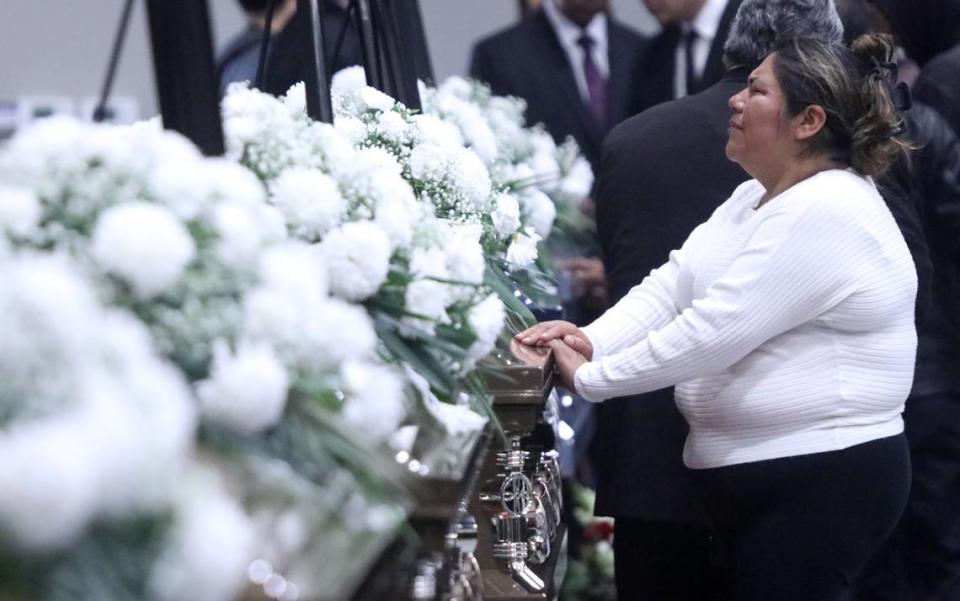 A woman pays her final respects for one of the seven farmworkers who died in a Feb. 23 crash in rural Madera County. A funeral mass was held at the Kerman High School multi-purpose room on March 9, 2023.