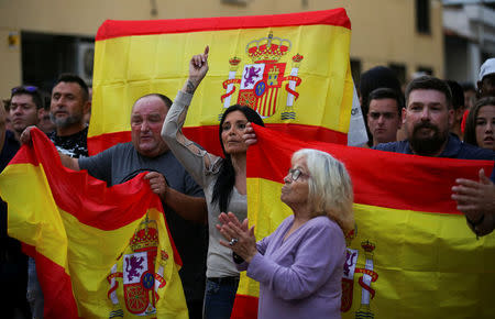 People who showed up to support the Spanish national police officers staying in town, hold up Spanish flags outside the police hotel in Pineda de Mar, north of Barcelona, Spain, October 3, 2017. REUTERS/Albert Gea