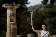 Olympics - Dress Rehearsal - Lighting Ceremony of the Olympic Flame Pyeongchang 2018 - Ancient Olympia, Olympia, Greece - October 23, 2017 Greek actress Katerina Lehou, playing the role of High Priestess, lights a torch from the sun's rays reflected in a parabolic mirror during the dress rehearsal for the Olympic flame lighting ceremony for the Pyeongchang 2018 Winter Olympic Games at the site of ancient Olympia in Greece REUTERS/Alkis Konstantinidis