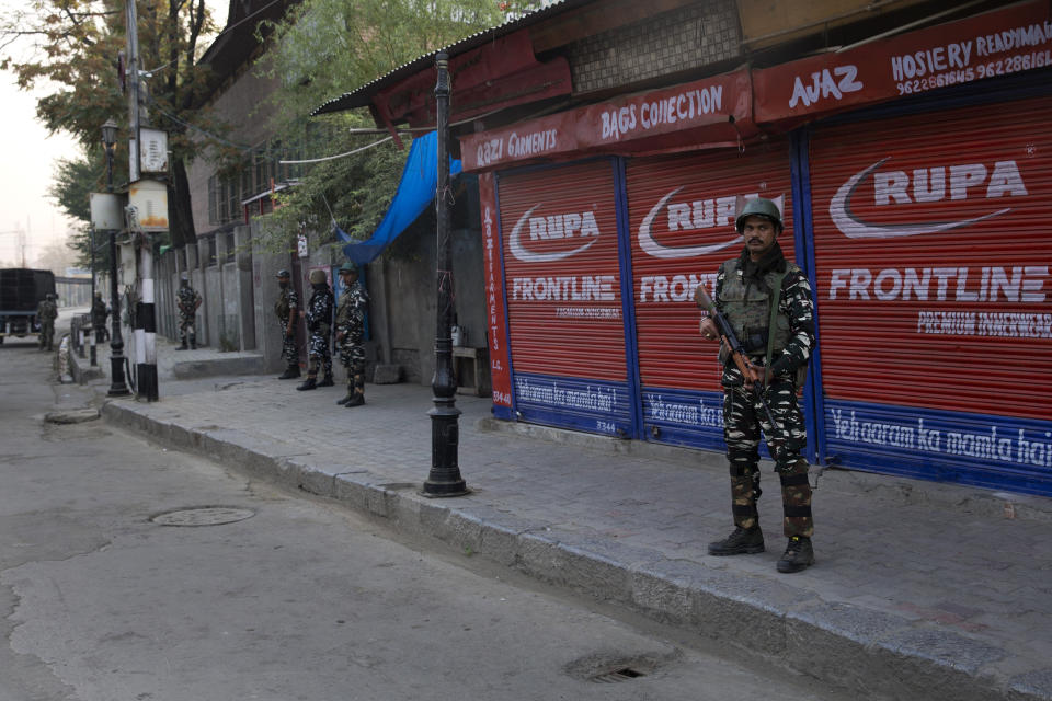 Indian paramilitary soldiers stands guard outside a closed market during restrictions in Srinagar Indian controlled Kashmir, Friday, Sept. 27, 2019. Residents in Indian-controlled Kashmir waited anxiously as Indian and Pakistani leaders were scheduled to speak at the U.N. General Assembly later Friday. (AP Photo/ Dar Yasin)