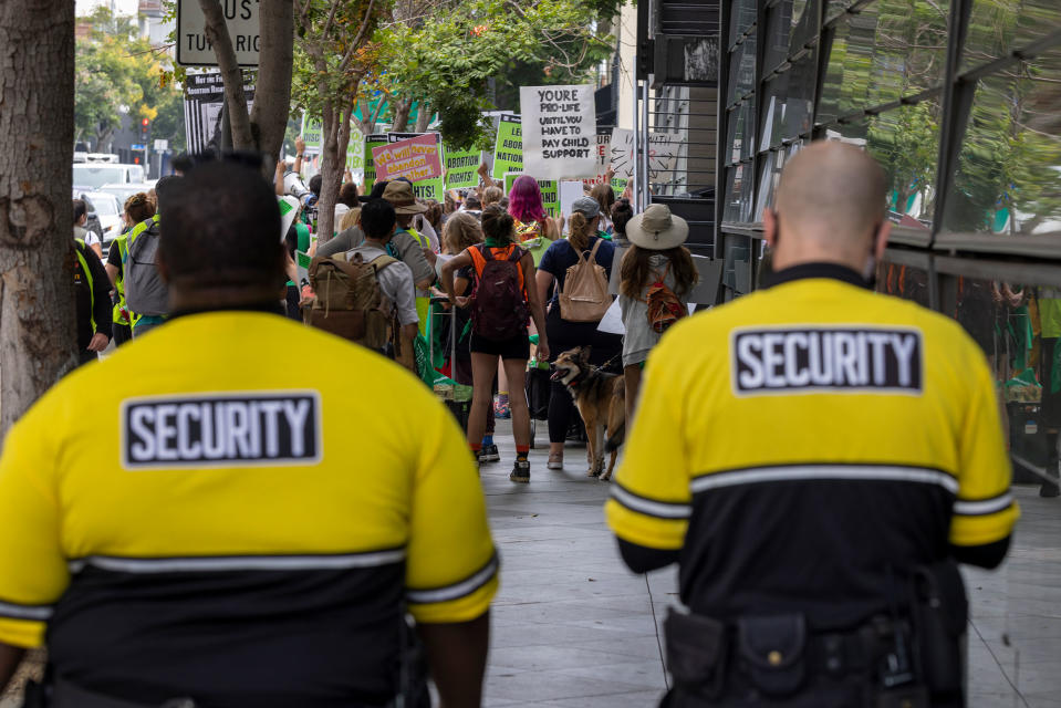 Private security guards follow behind protesters marching to a Planned Parenthood office to denounce the US Supreme Court decision to end abortion rights protections in Santa Monica, Calif. on July 16, 2022.<span class="copyright">David McNew—Getty Images</span>