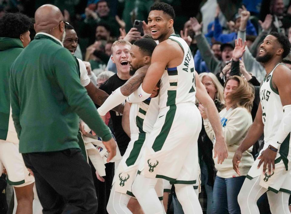 Bucks guard Damian Lillard gets a hug from Giannis Antetokounmpo after draining a long three-pointer at the buzzer in overtime to beat the Kings on Sunday night at Fiserv Forum.