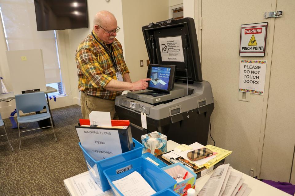 Mecklenburg County elections worker Ward Cates stands next to ballot equipment at an early polling location in Charlotte.