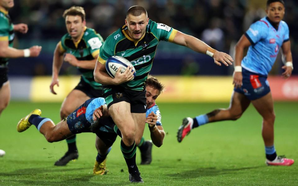 Ollie Sleightholme of Northampton runs with the ball away from a diving tackle by Sebastian de Klerk of Bulls