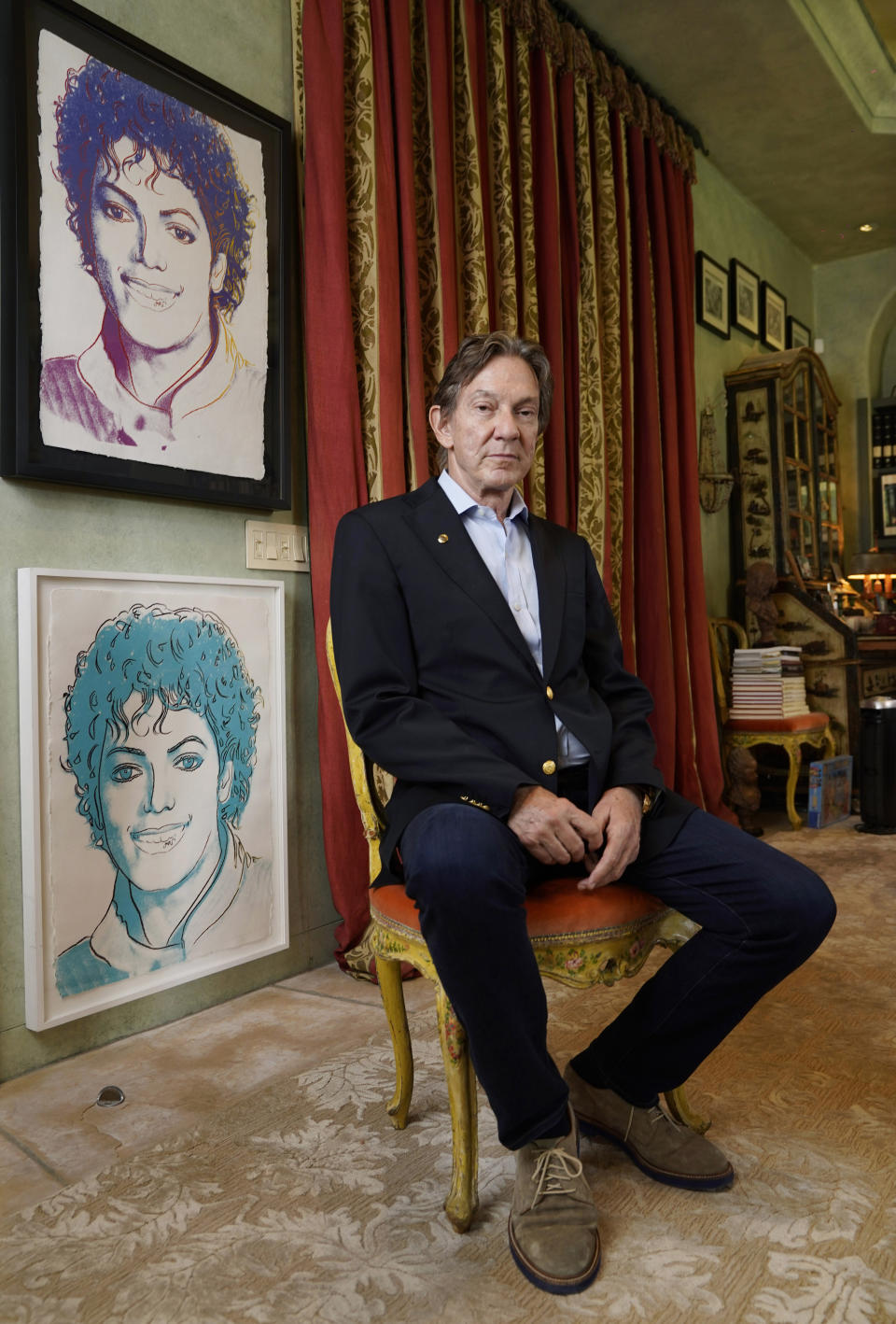 Entertainment attorney and Michael Jackson Estate co-executor John Branca poses alongside Andy Warhol prints of Jackson, Thursday, July 8, 2021, at his home in Los Angeles. (AP Photo/Chris Pizzello)