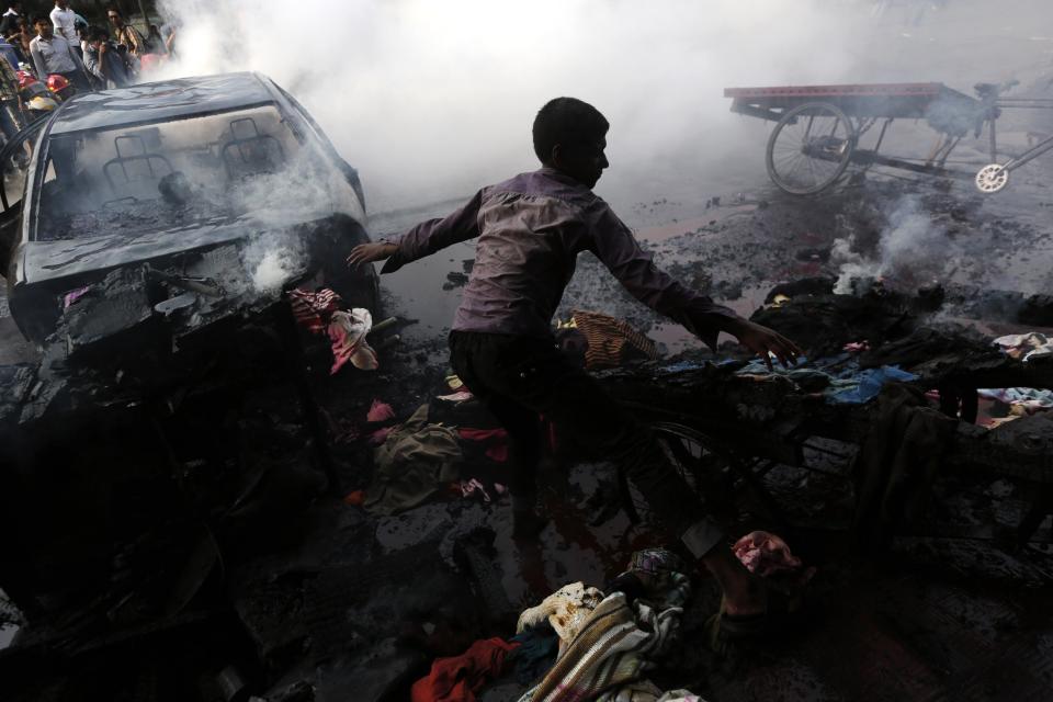 A boy tries to control a fire after vehicles were torched and vandalized by Bangladesh's Jamaat-e-Islami party activists during clashes with police in Dhaka