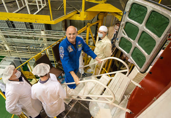 Astronaut Scott Kelly wearing a NASA blue flight suit with patches for his four International Space Station expeditions and yearlong mission.