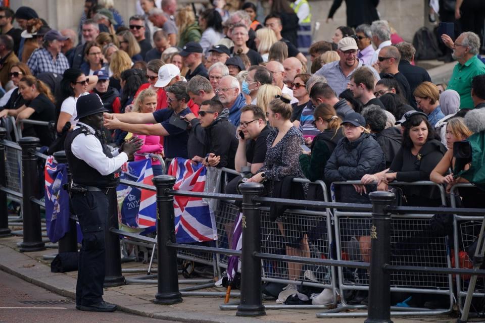 Members of the public wait near to Buckingham Palace ahead of the ceremonial procession of the coffin of Queen Elizabeth II, from Buckingham Palace to Westminster Hall (PA)