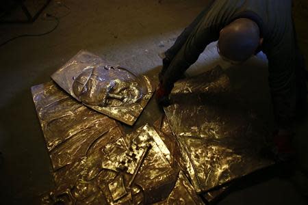 A bas-relief of the late Pope John Paul II, made of bronze, is being worked on in Krakow April 17, 2014.REUTERS/Kacper Pempel