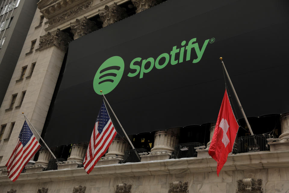 The Spotify logo hangs on the facade of the New York Stock Exchange with U.S. and a Swiss flag as the company lists it's stock with a direct listing in New York, U.S., April 3, 2018. REUTERS/Lucas Jackson